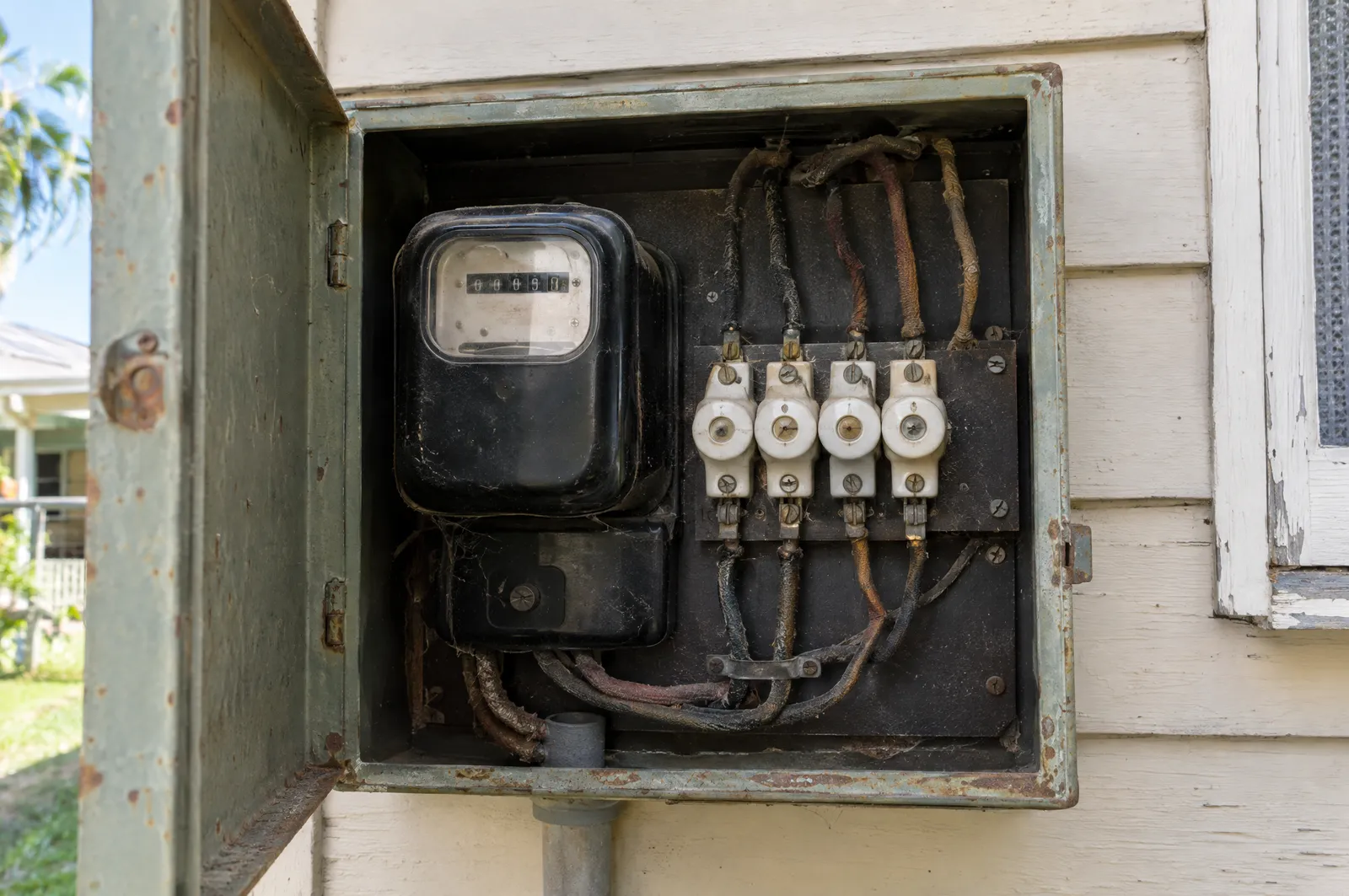 Old meter box with ceramic rewireable fuses on an older Queensland home, a common reason for a switchboard upgrade